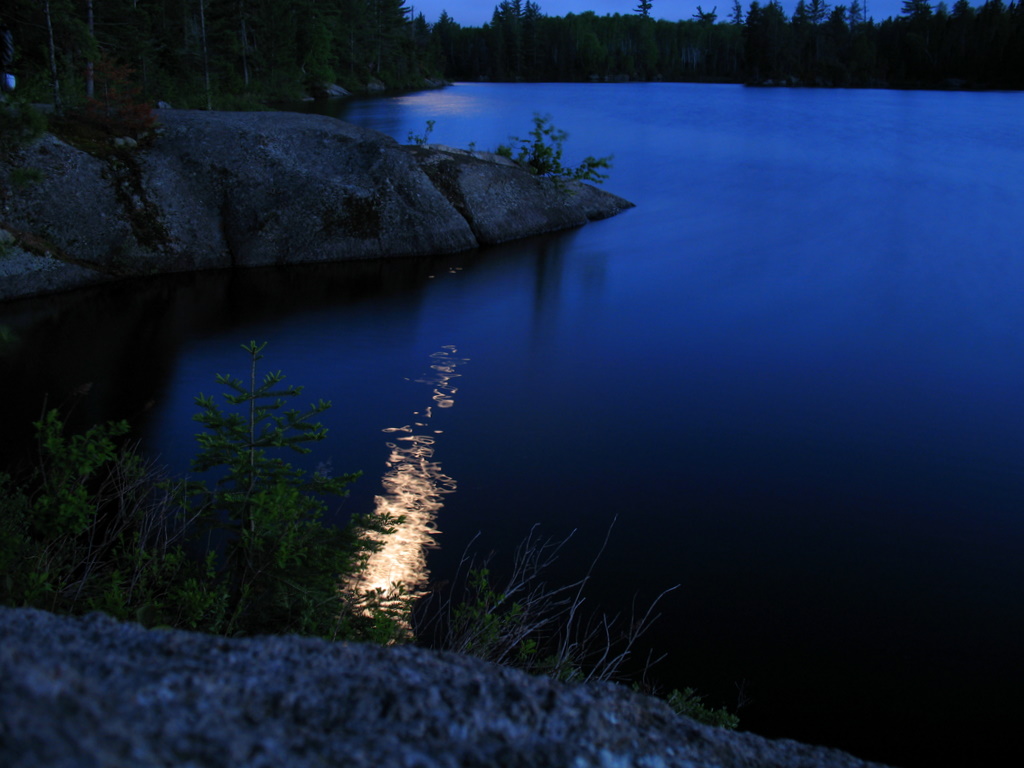 A nighttime photo of the moonlight dancing on the waters in the BWCA, Boundary Waters Canoe Area.