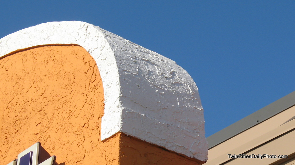 The top corner of the entrance to a very well known fast food joint. The contrasting colors caught my eye while I was waiting in line.